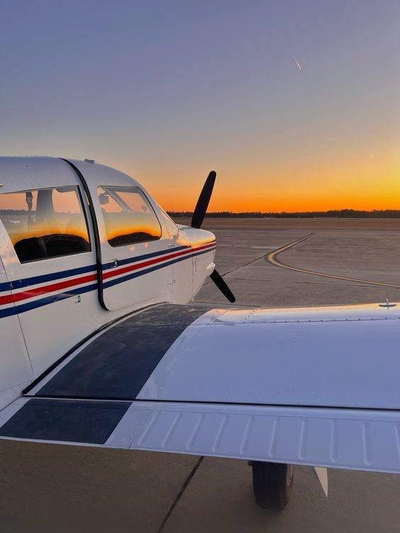 Pelican Flight School airplane against the backdrop of a sunset